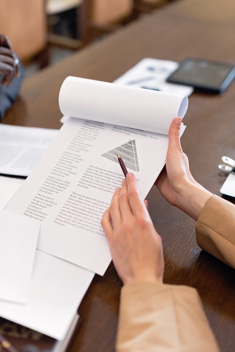 Close-up of hands holding a document with a pen pointing at a chart, perfect for business presentations.